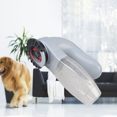 An image of the Saint N Mike Cordless Pet Hair Portable Brush Vacuum with a golden retriever in the background.